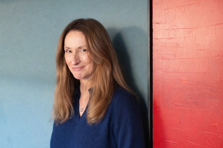 Jenny Williams ICF Coach standing by a red wall