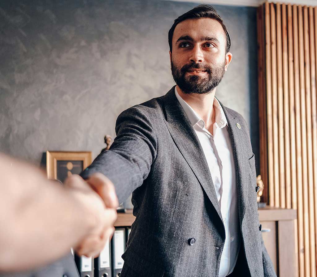 Confident interview candidate offering a handshake, symbolizing strong interview presence and identity.